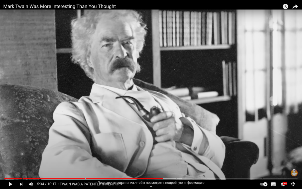 Mark Twain sits in a chair and smokes