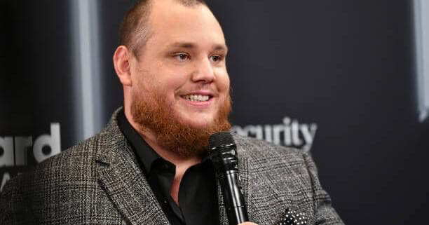 Luke Combs holding a microphone